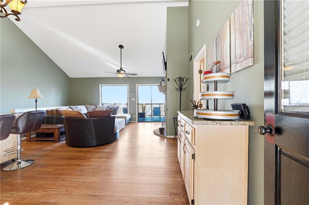 Living room with hardwood floors, a ceiling fan, and sliding glass doors.
