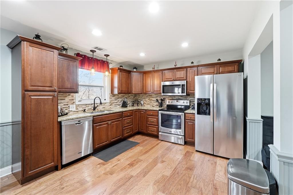 Kitchen with cherry cabinets, granite countertops, and stainless steel appliances.