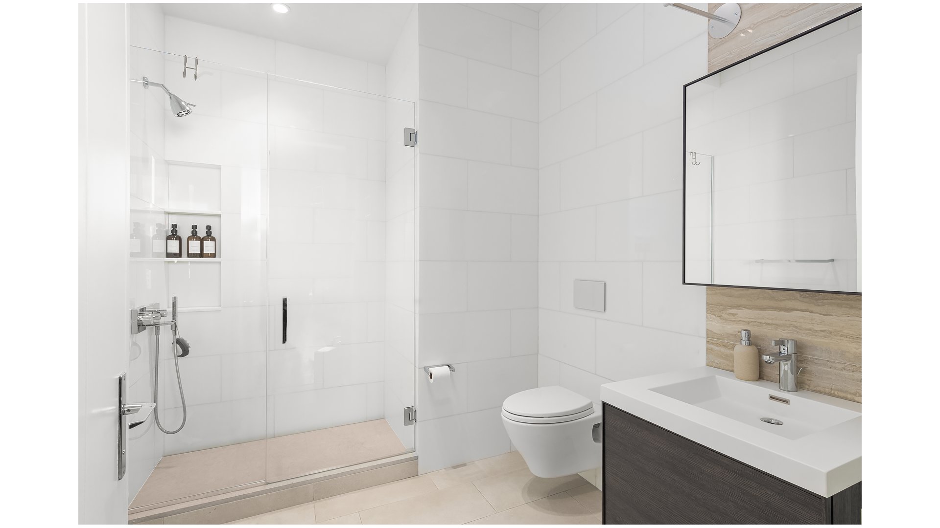 Modern bathroom with a glass-enclosed shower, wall-mounted toilet, and floating vanity.