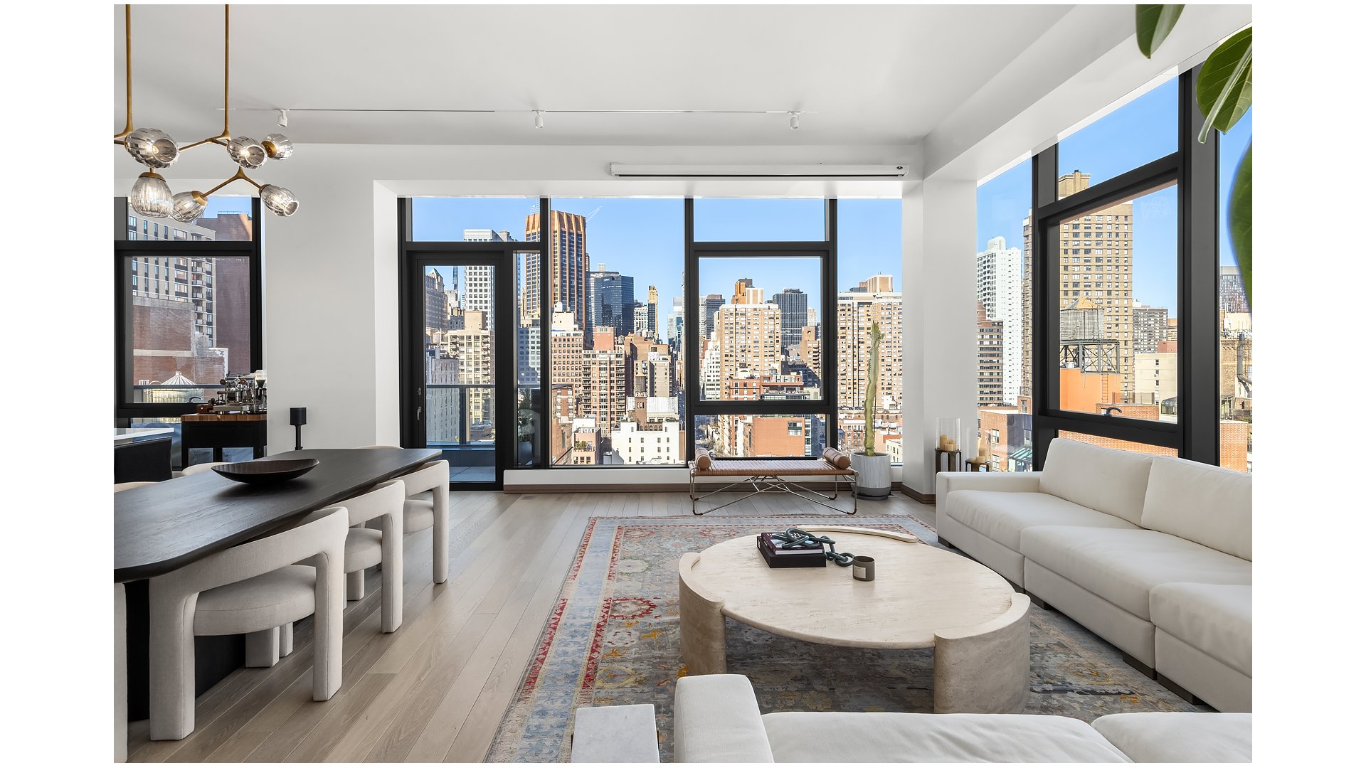 Open-plan living and dining room with floor-to-ceiling windows overlooking the Manhattan skyline.