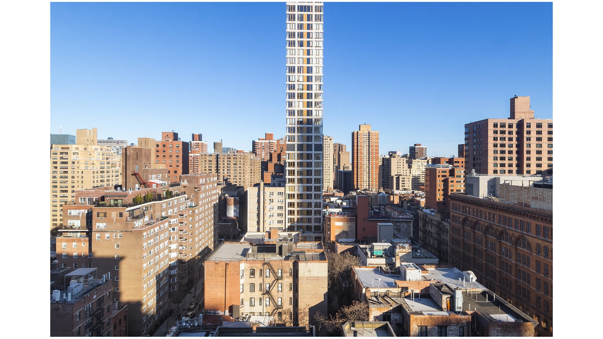 Manhattan cityscape with a slender modern tower rising above surrounding buildings.
