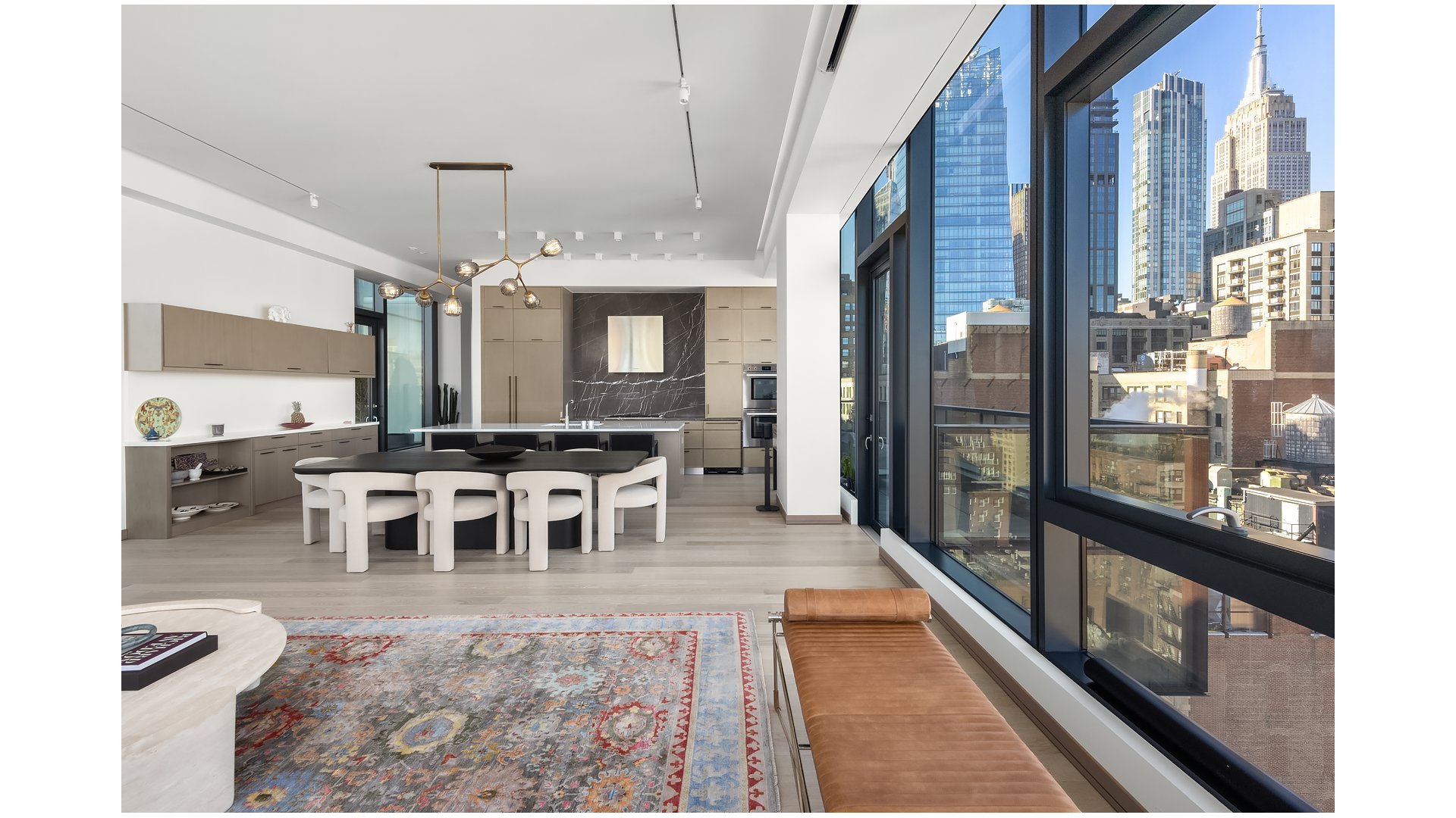 Open-plan kitchen and dining area with floor-to-ceiling windows overlooking the Manhattan skyline.