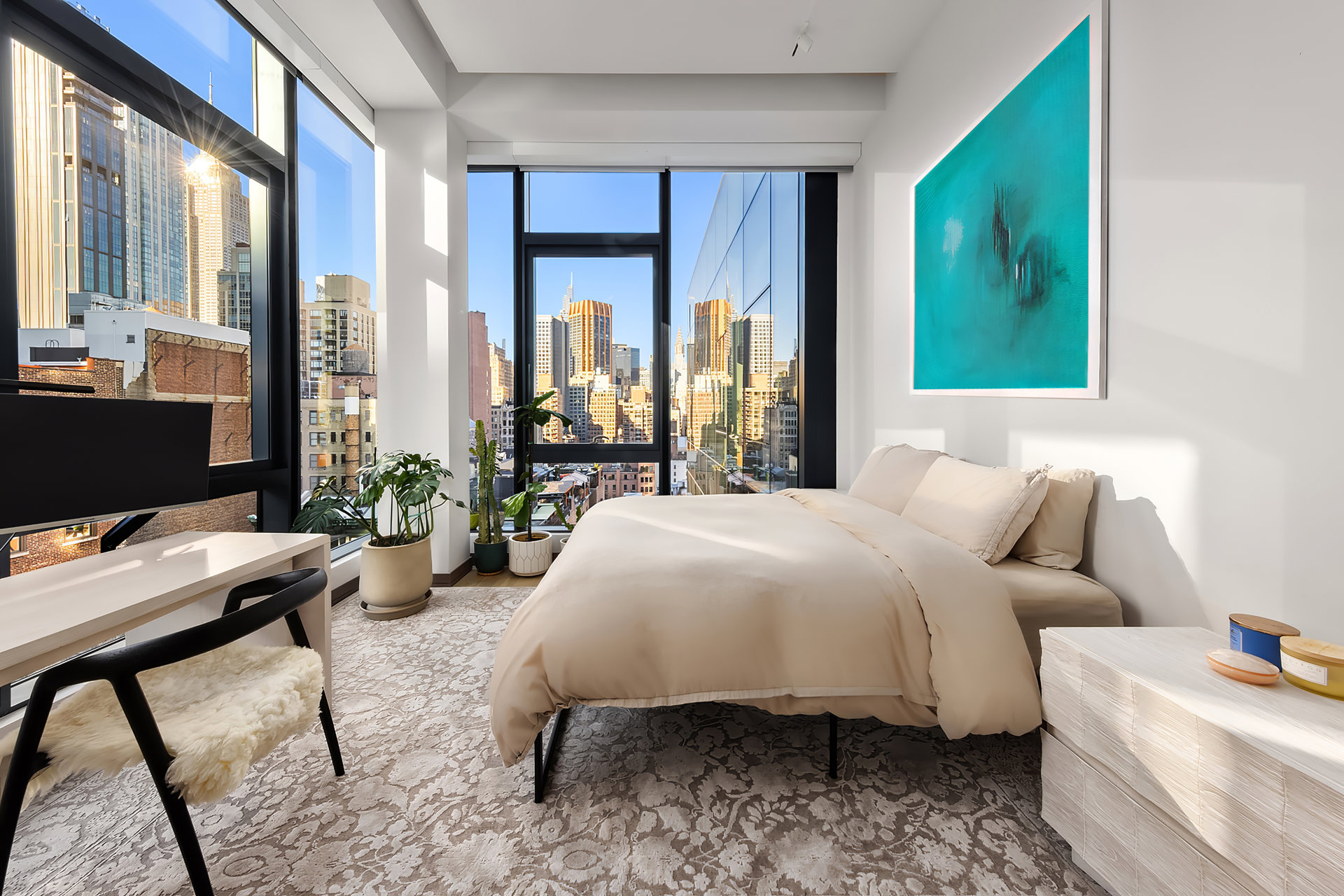 Furnished bedroom with floor-to-ceiling windows overlooking the Manhattan skyline.