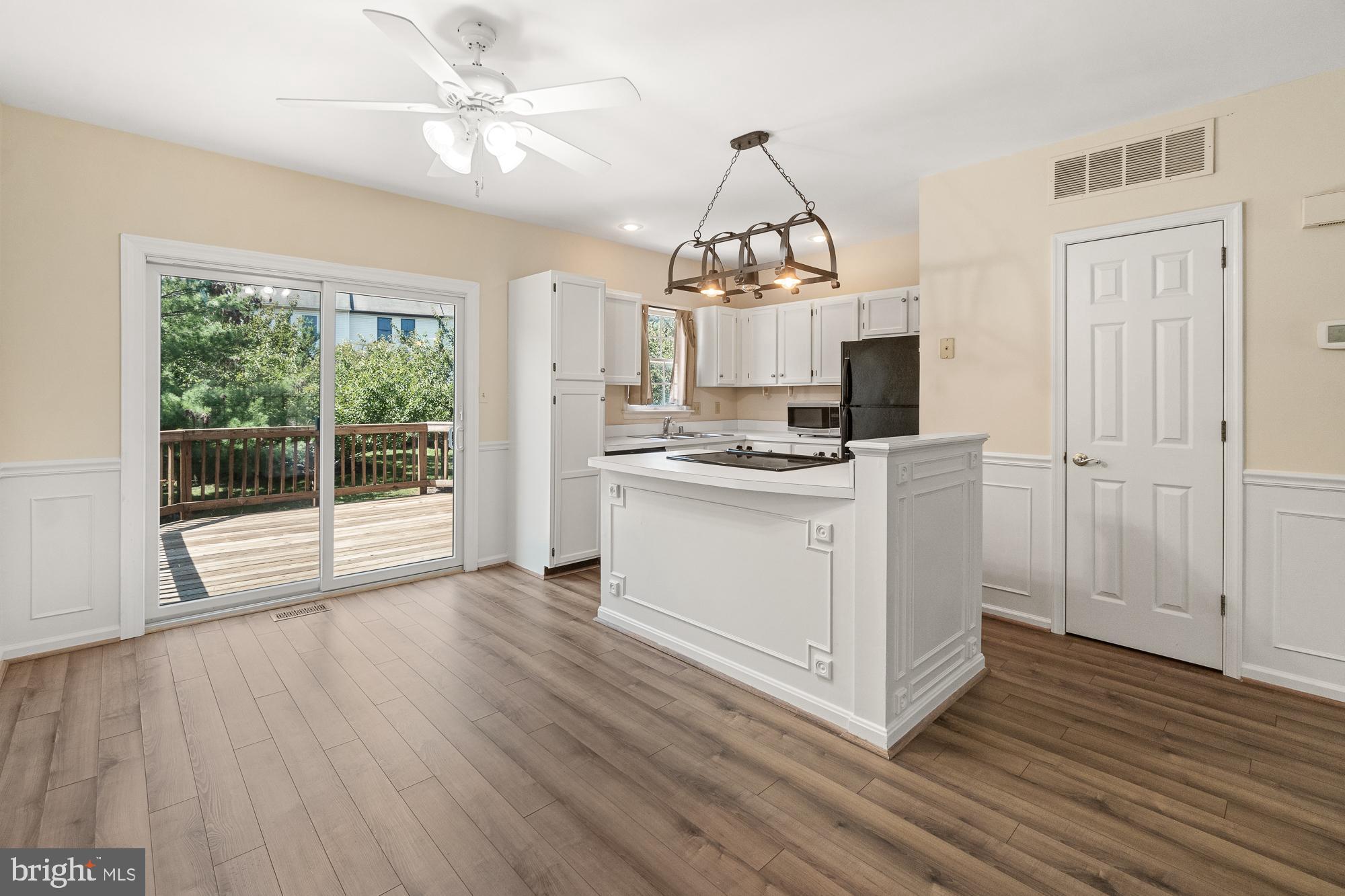 Kitchen with a large white island and sliding glass doors opening onto a wooden deck.