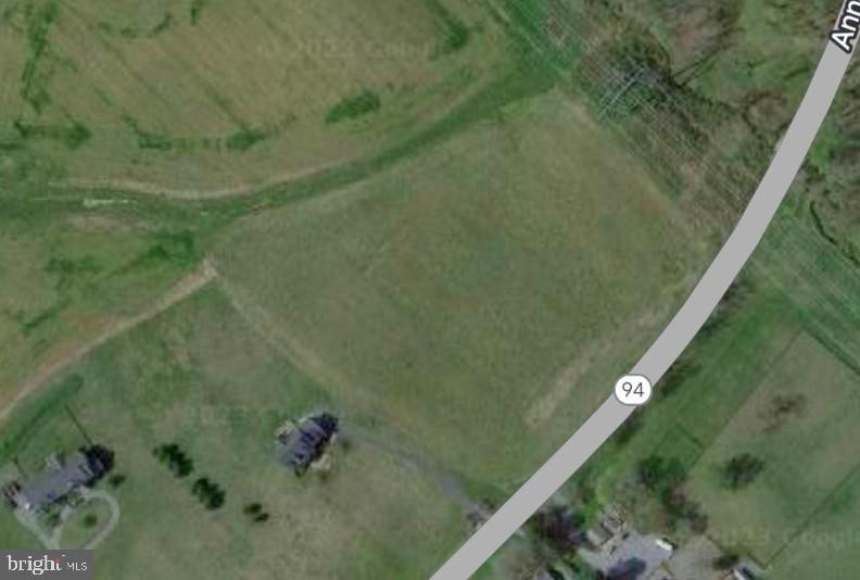 Aerial view of open fields and scattered homes beside Route 94.