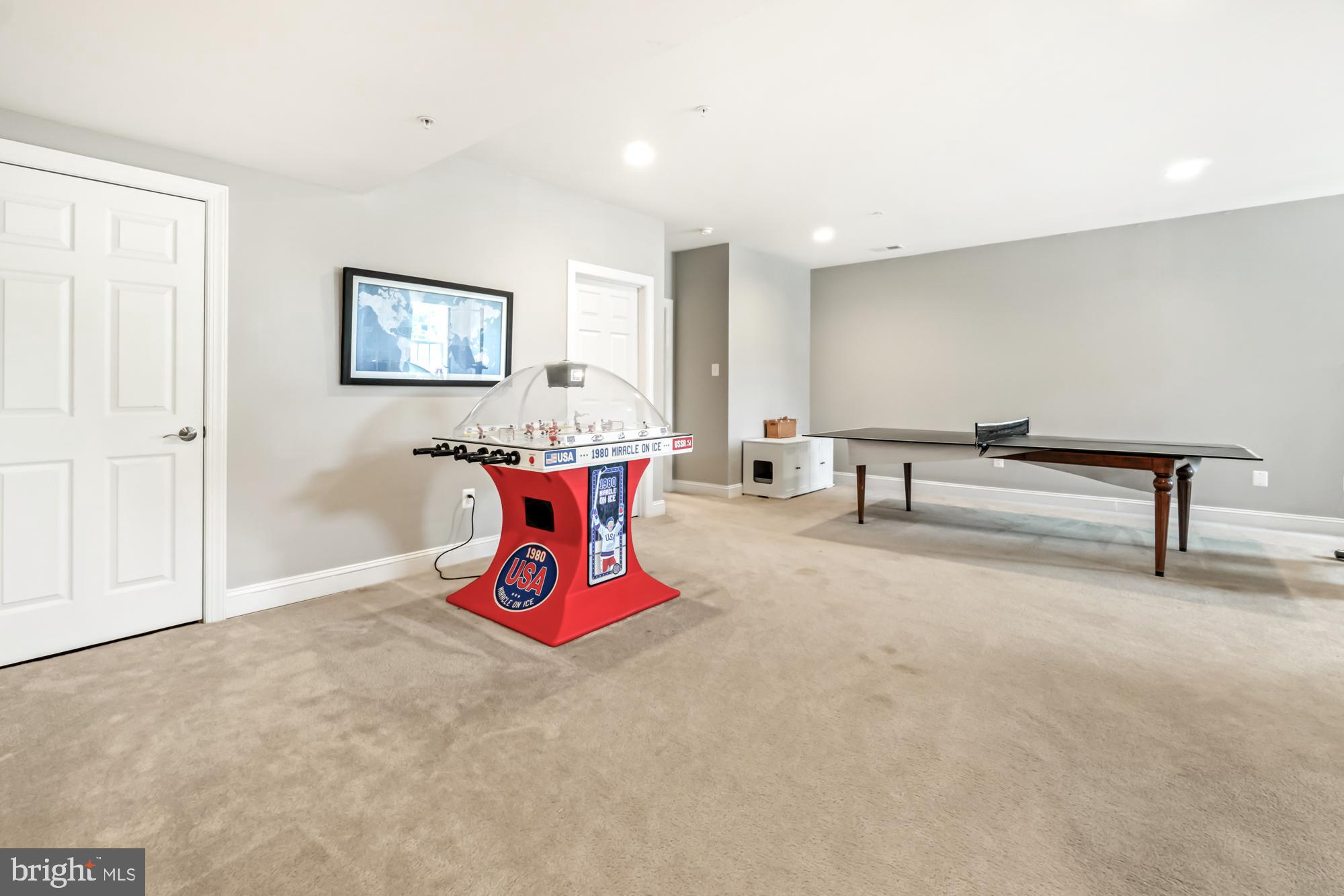 Finished basement game room with a red foosball table and a ping-pong table.