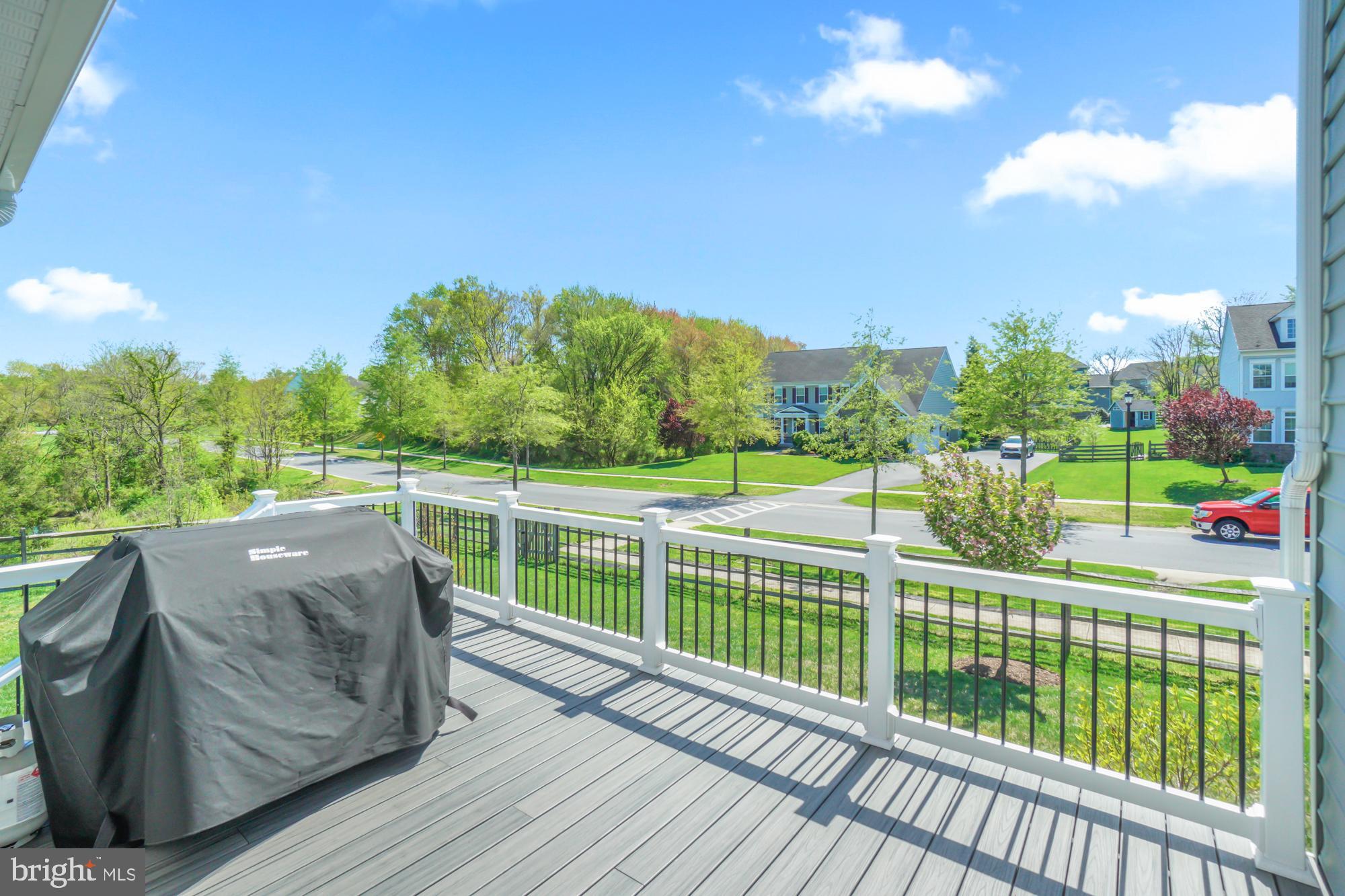 Composite deck with covered grill overlooking a leafy suburban neighborhood.