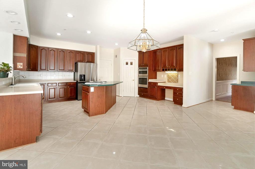 Kitchen with dark wood cabinetry, stainless steel appliances, and a central island.