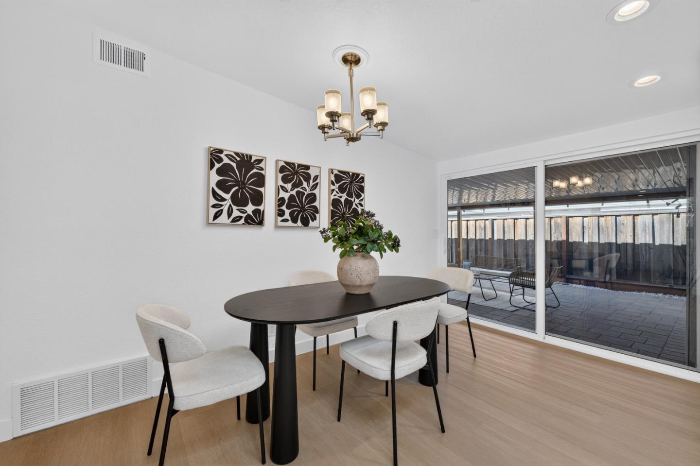 Dining room with an oval table and patio access through wide sliding glass doors.