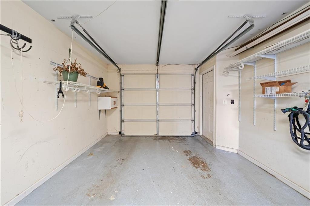 Single-car garage with a closed overhead door and wire storage shelves along both walls.