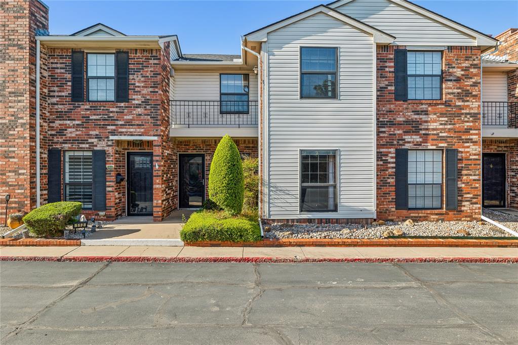 Attached brick-and-siding homes with dark shutters, balconies, and landscaped entryways.