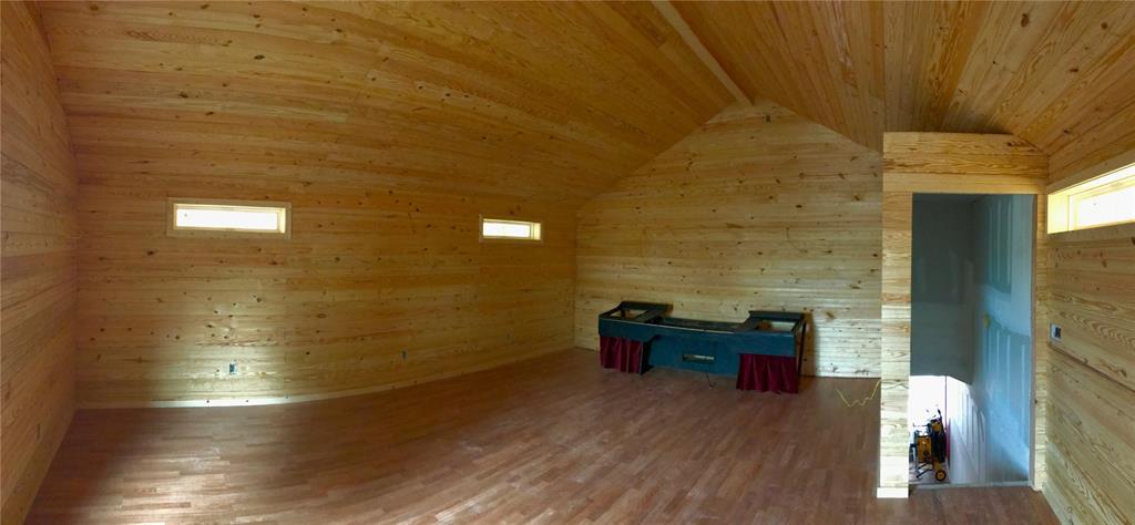 Wood-paneled game room with a foosball table and open stairwell.