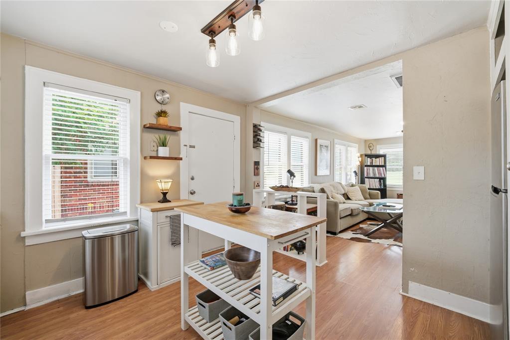 Open-plan kitchen with a wood-topped island and furnished living area beyond.