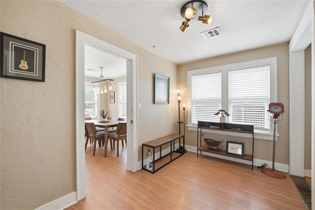 Living room with large windows, a media console, and a view into the dining room.