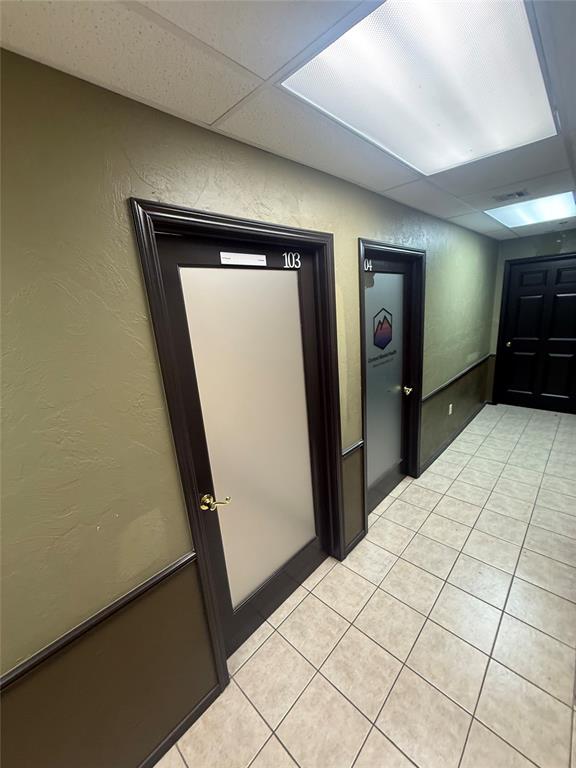 Commercial hallway with tiled floors and suite doors marked 103 and 04.