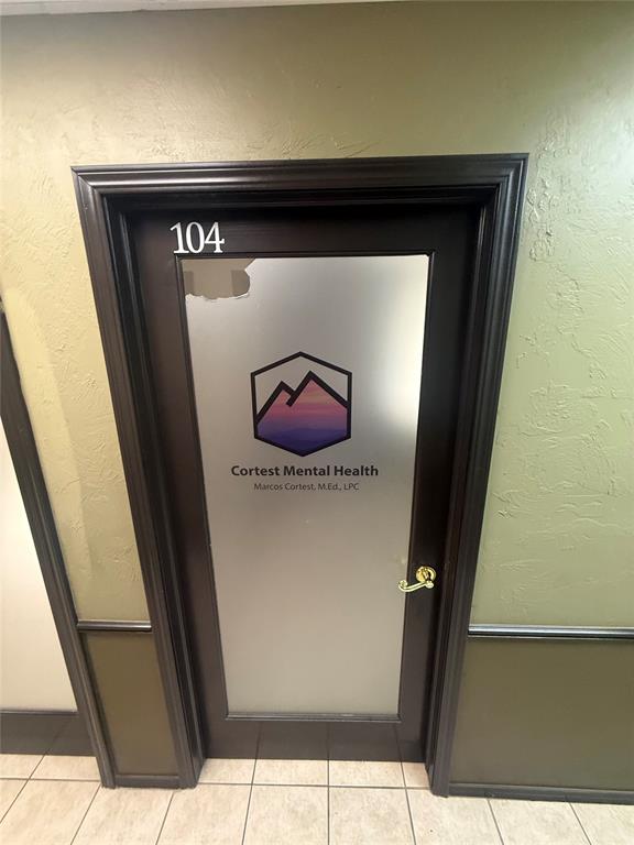 Commercial hallway door marked 104 for Cortest Mental Health, with pale green walls and a tiled floor.