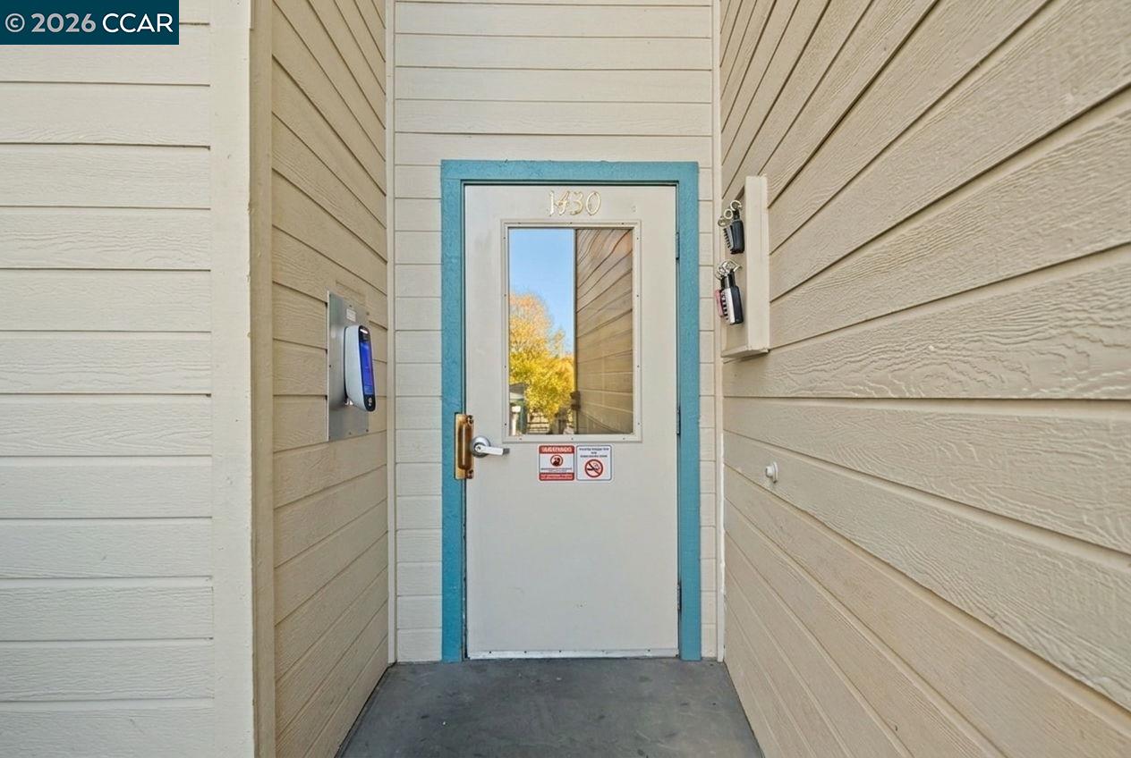 Property entrance with a white door marked 1430, turquoise trim, and an entry keypad.
