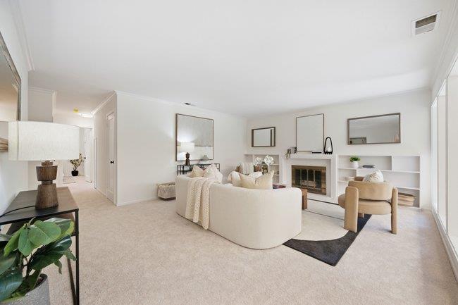 Staged living room with a fireplace, built-in shelving, and a light-colored sofa.