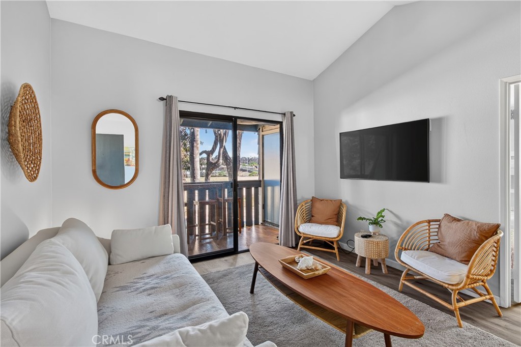 Furnished living room with wicker chairs and sliding doors opening to a balcony.