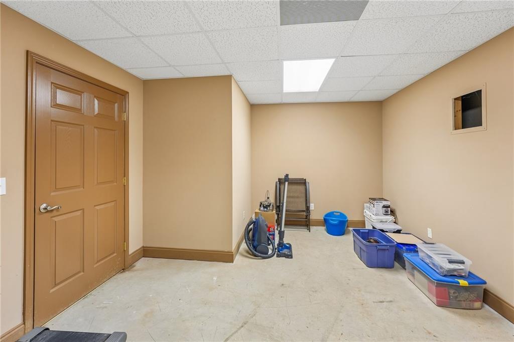 Utility room with a brown paneled door, cleaning equipment, and plastic storage bins.