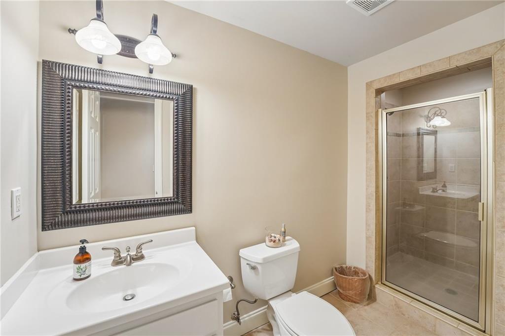 Bathroom with a white vanity, dark framed mirror, and glass-enclosed tiled shower.