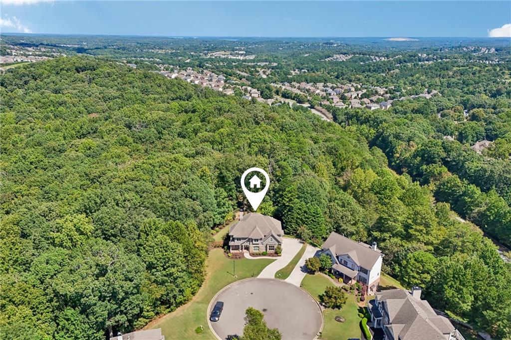 Aerial view of a house on a wooded cul-de-sac, marked with a location pin.