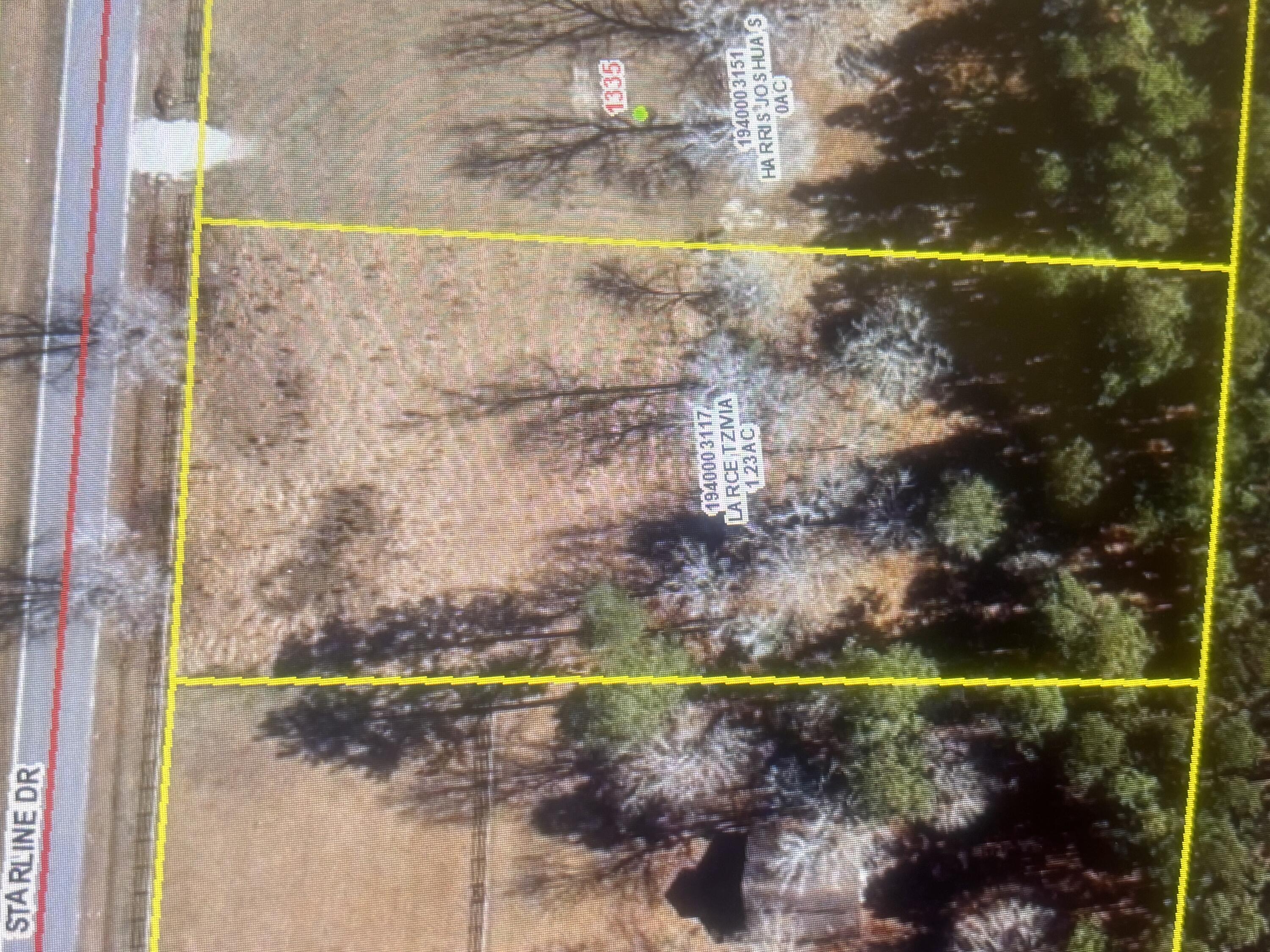 Aerial view of a wooded lot outlined in yellow beside Starline Drive.
