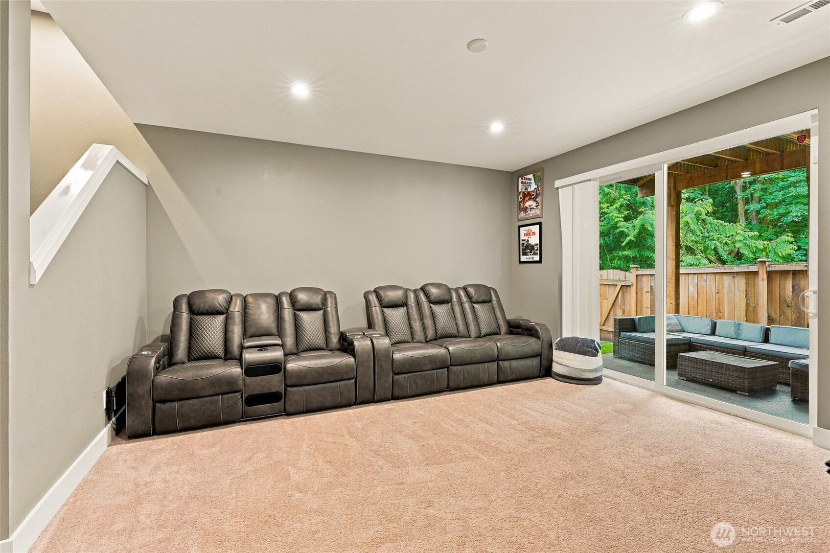 Media room with leather reclining seats and sliding doors to a covered patio.