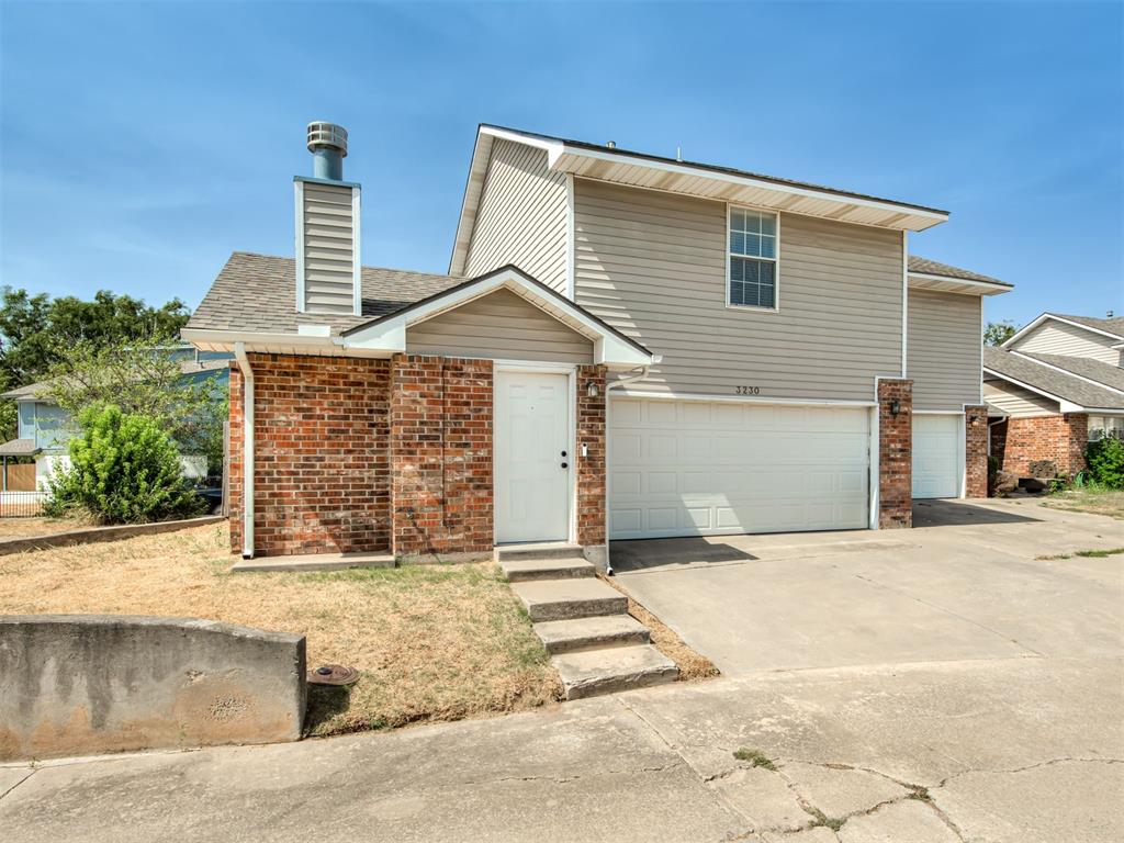 Two-story brick and siding home with an attached garage and concrete driveway.