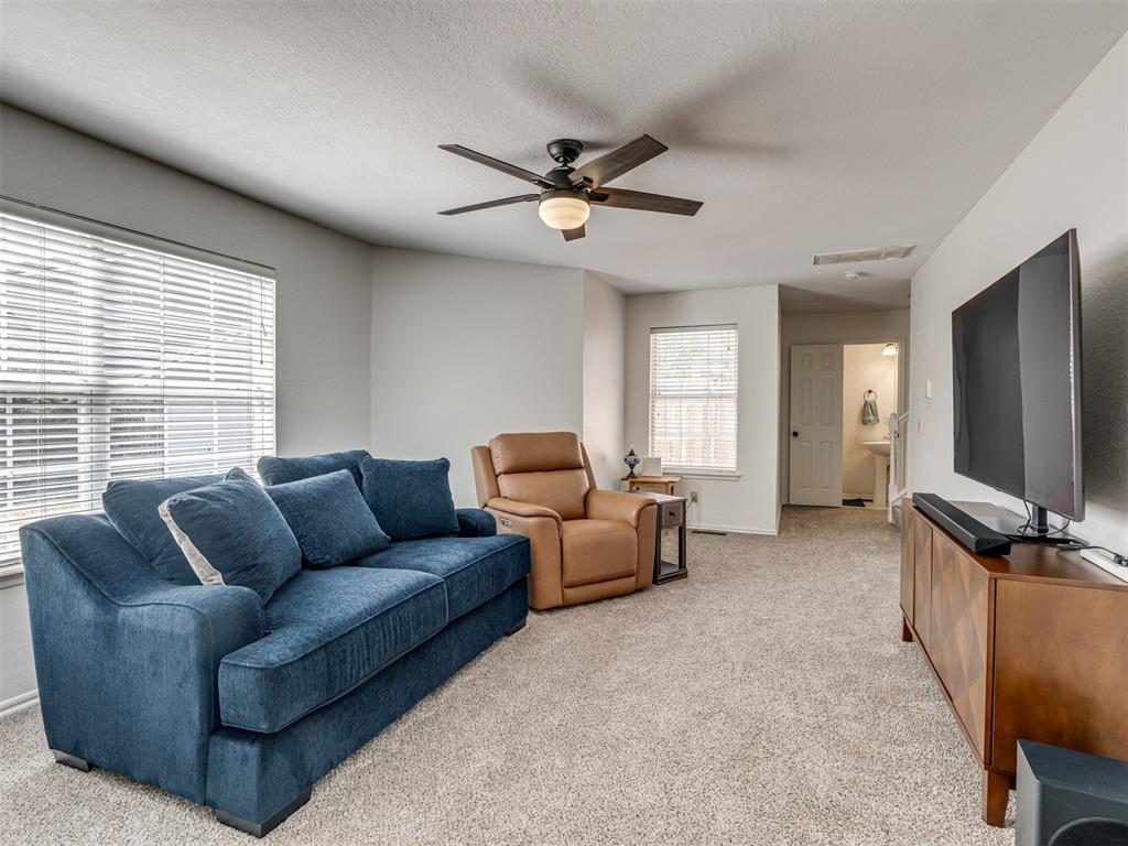 Living room with a blue sofa, tan recliner, and wall-mounted television.