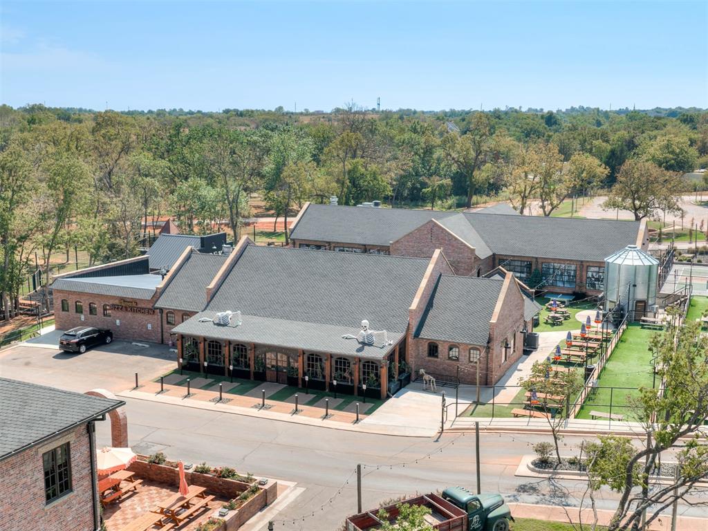 Brick restaurant complex with a fenced patio and outdoor picnic tables, viewed from above.