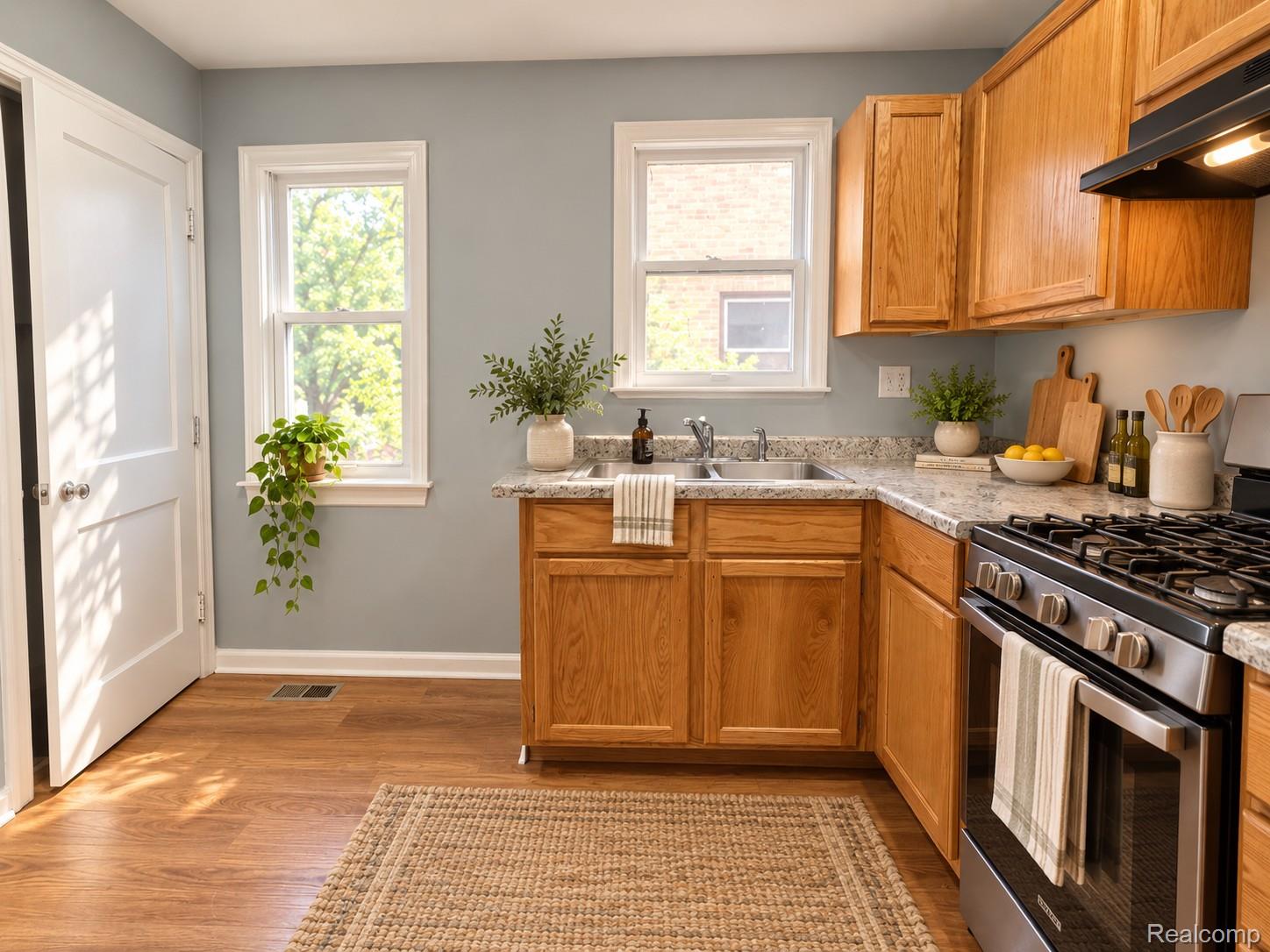 Kitchen with honey-toned wood cabinets, granite counters, and a stainless steel gas range.
