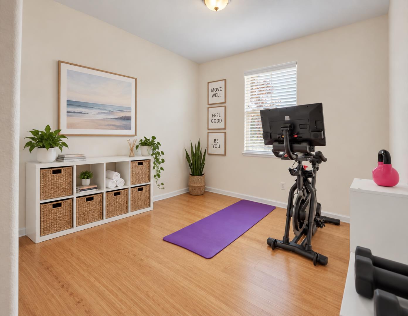 Home exercise room with an exercise bike, purple yoga mat, and bamboo flooring.