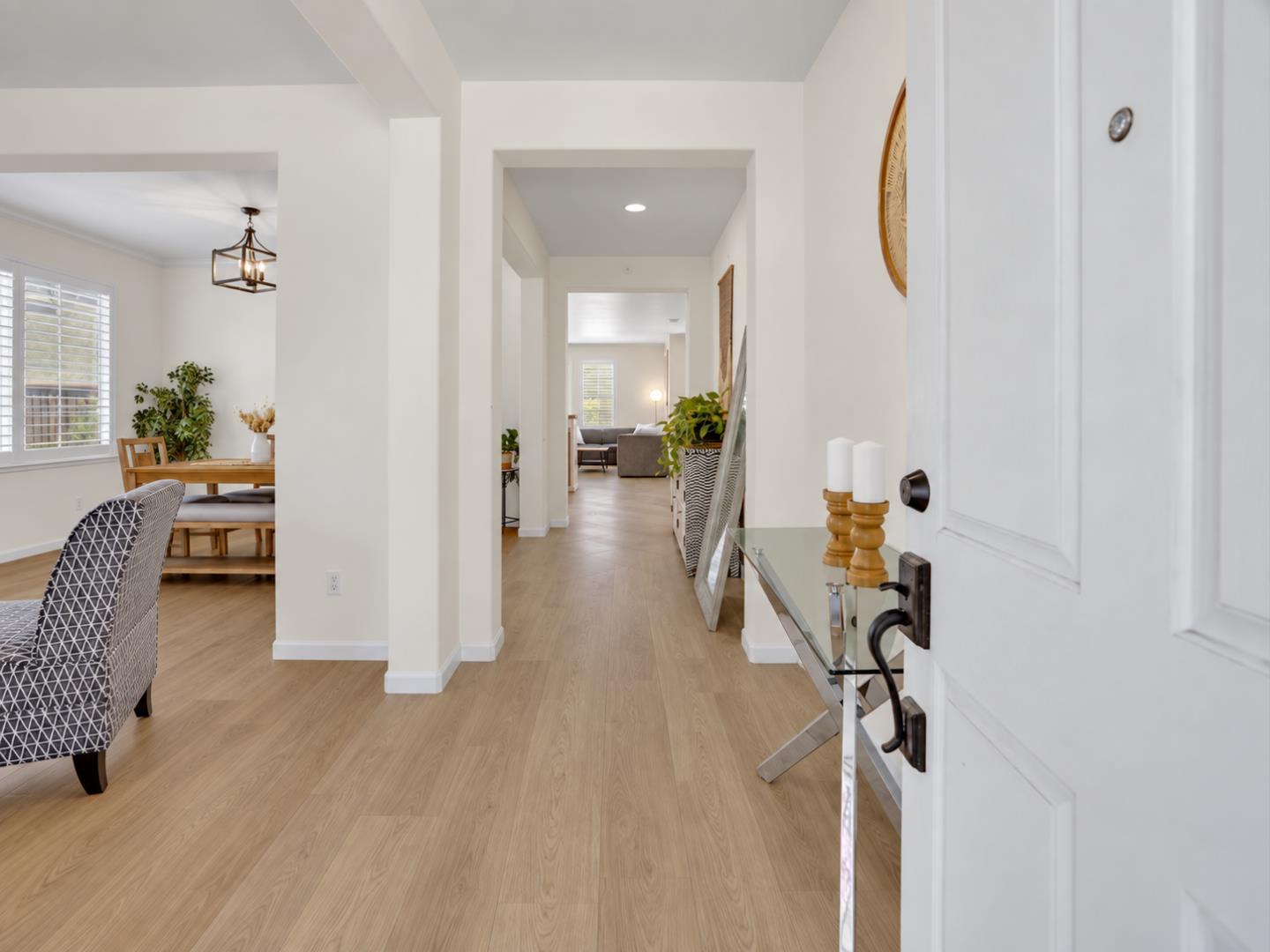 Furnished entryway with light wood flooring, opening onto the living room and dining area.