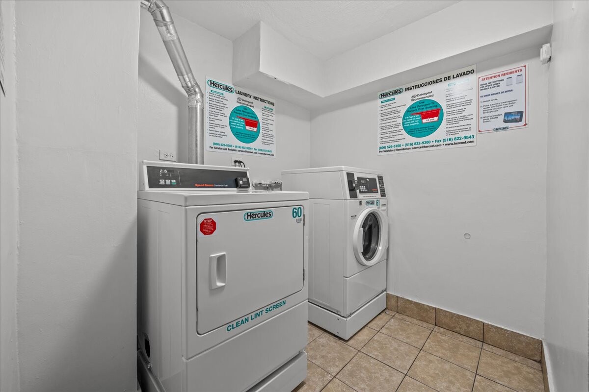 Shared laundry room with commercial dryer, front-loading washer, and instruction signs.