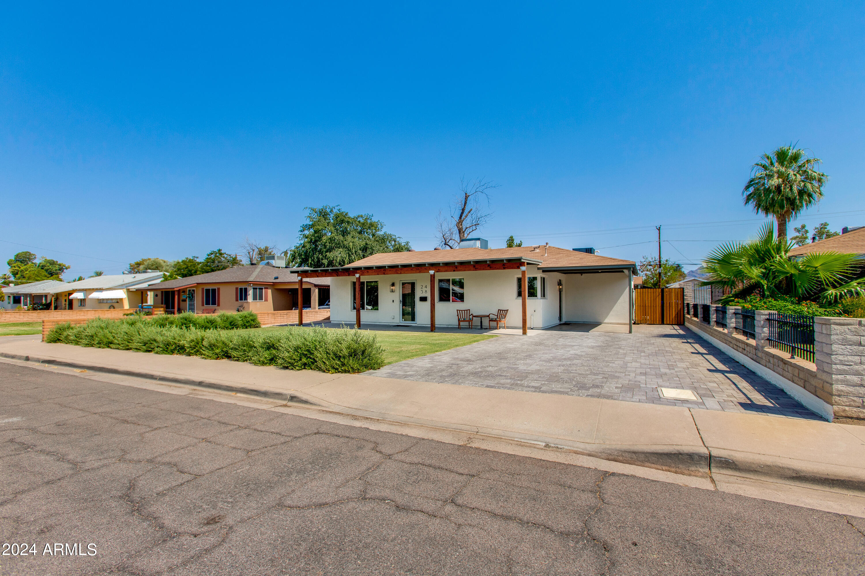 Single-story white home with a covered porch and wide paved driveway.