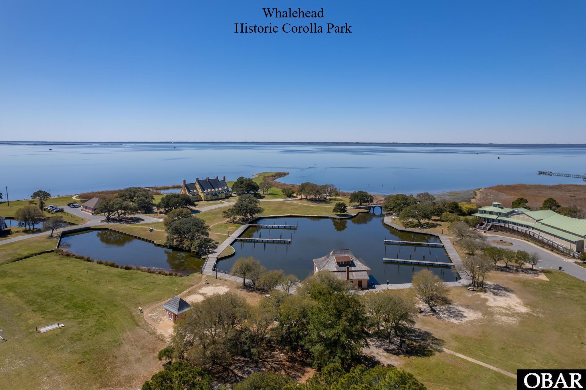 Aerial view of Whalehead Historic Corolla Park, showing its lagoon, docks, historic buildings, and waterfront.