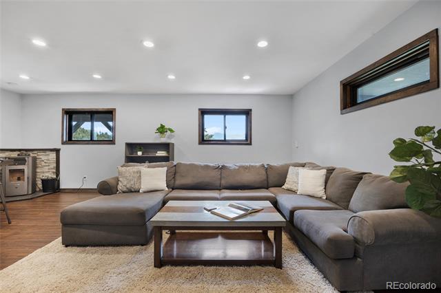 Living room with a gray sectional, light rug, coffee table, and small fireplace.