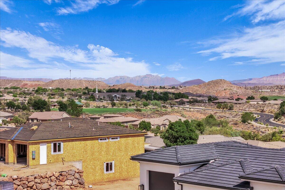 Elevated view over a residential neighborhood toward desert hills and distant mountains.