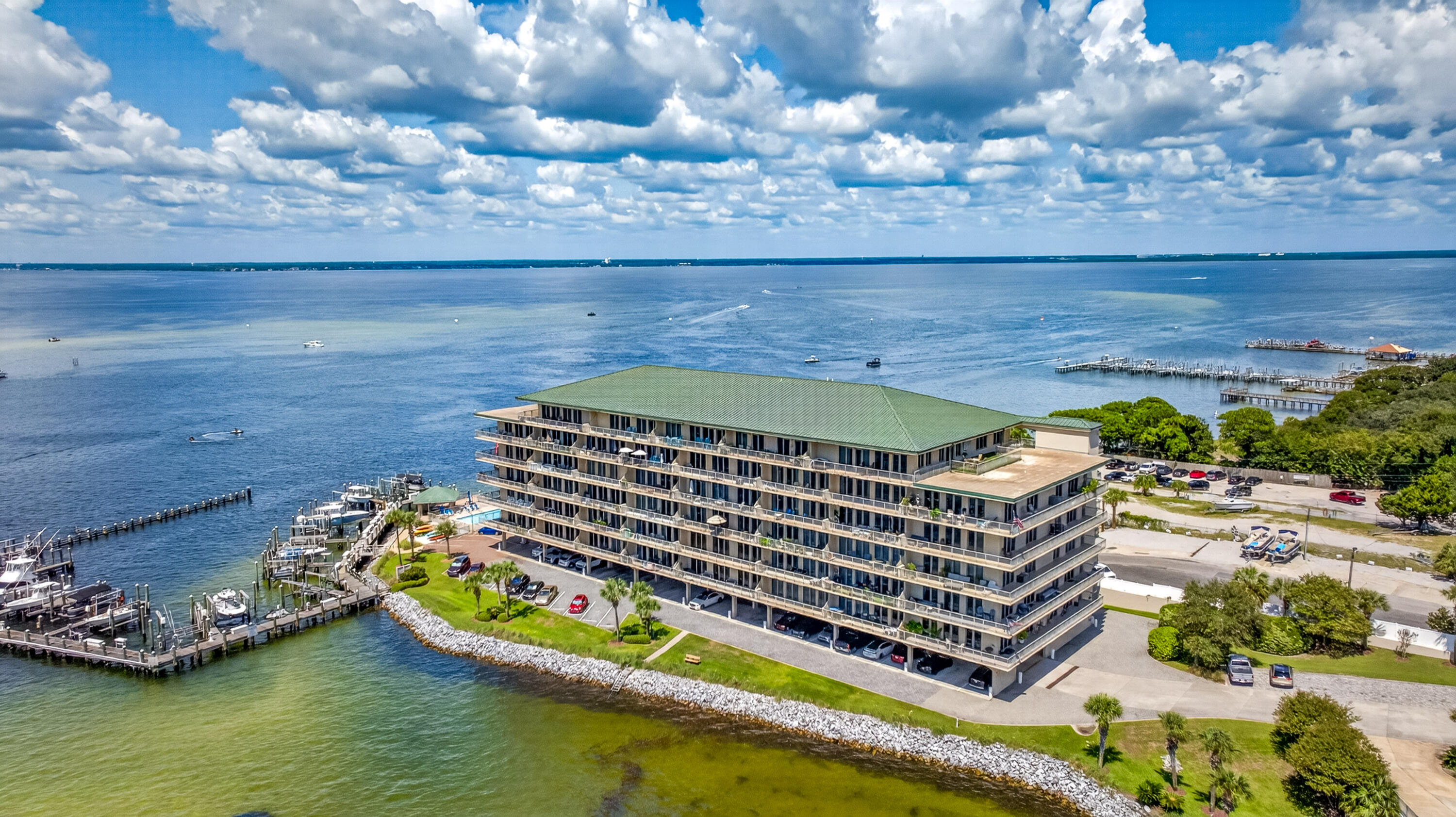Waterfront condominium complex beside the bay, with marinas and docks visible on both sides.