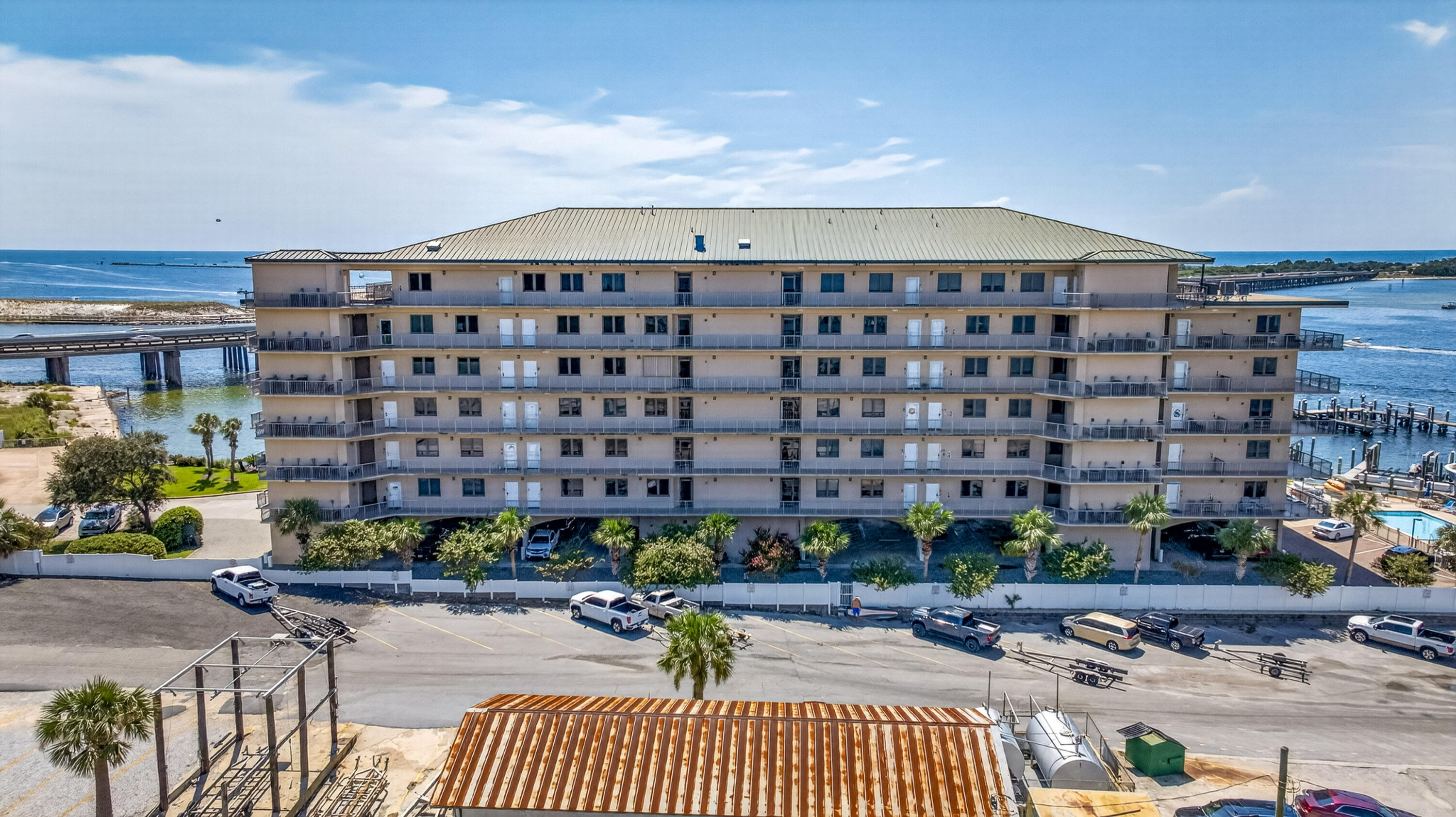 Waterfront condominium with rows of balconies, docks, and a pool beside the Gulf.