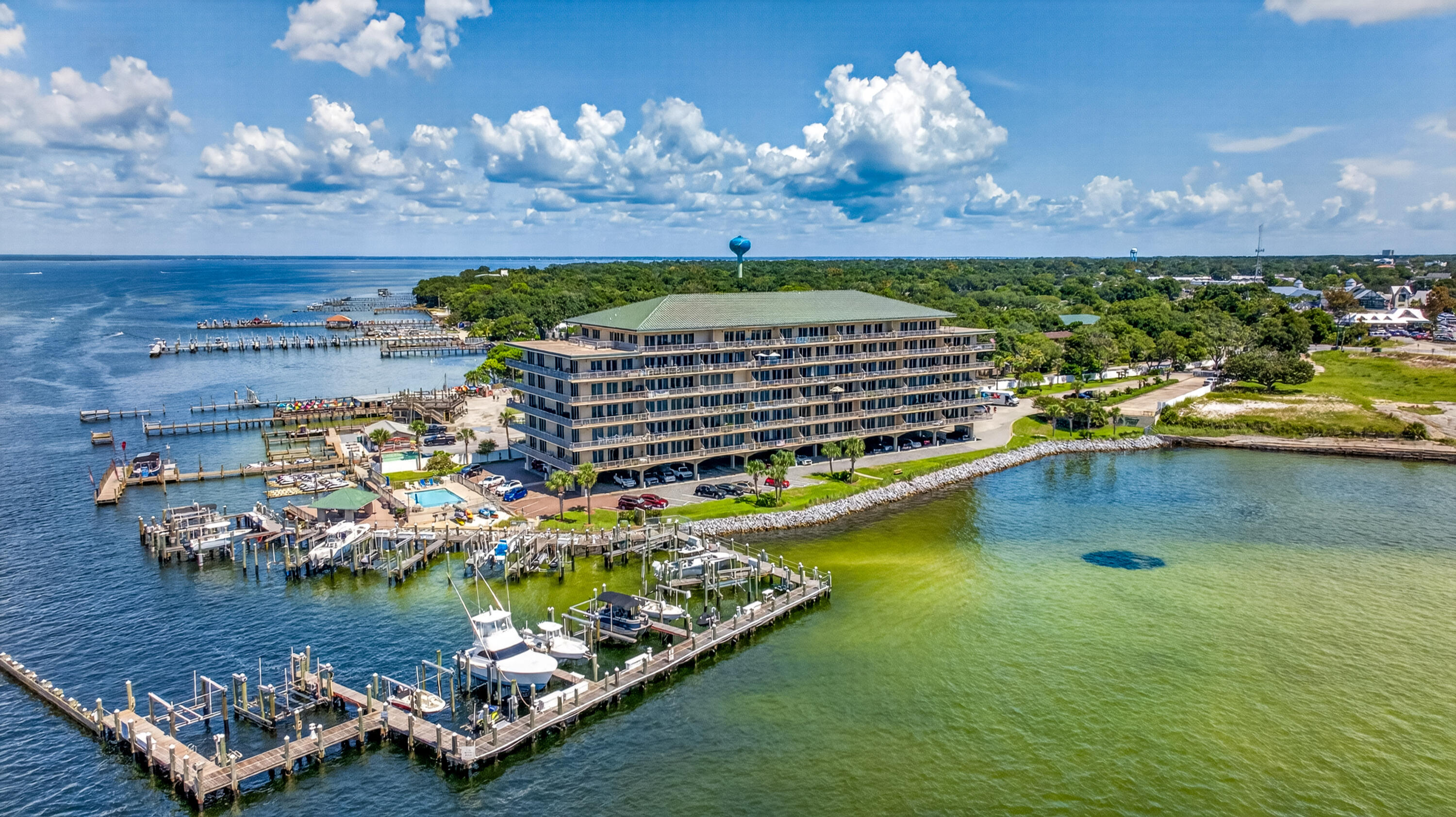 Waterfront condominium with marina docks and boats extending into the bay.