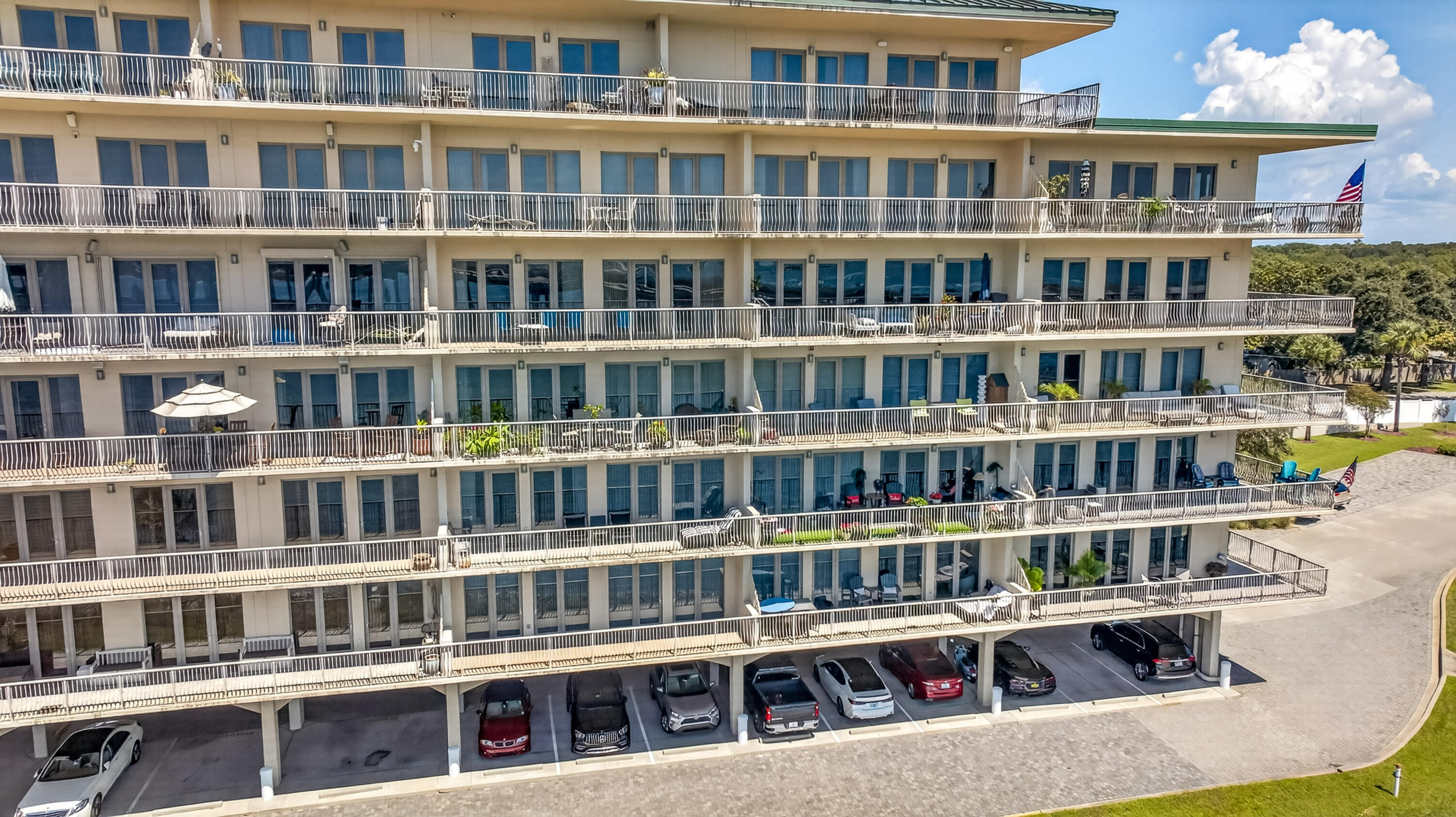 Multi-story condominium with long balconies and covered parking beneath.