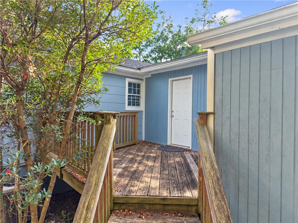 Blue house side entrance with a white door and raised wooden walkway.