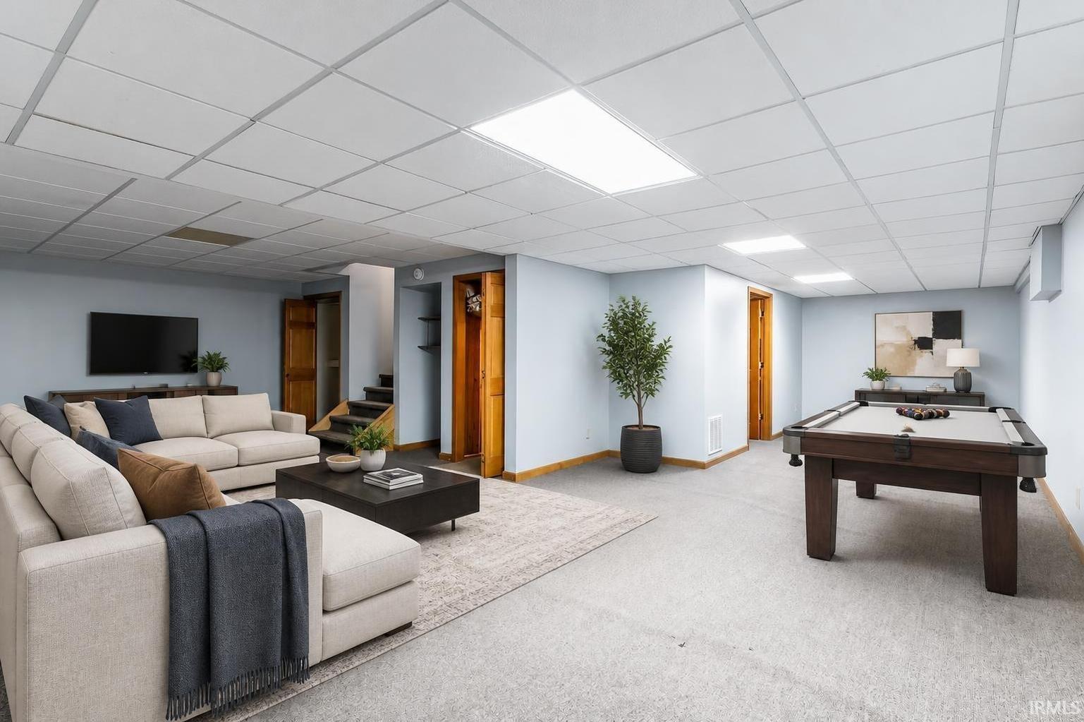 Recreation room with a beige sectional sofa and a dark wood pool table.