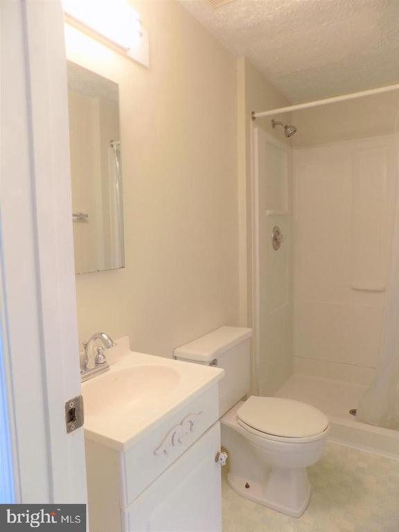 Bathroom with a white vanity, toilet, and tub-shower.