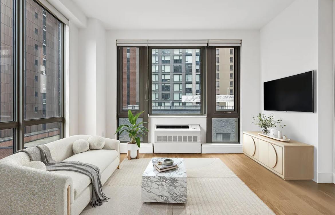 Living room with floor-to-ceiling windows, a white sofa, and a marble coffee table.