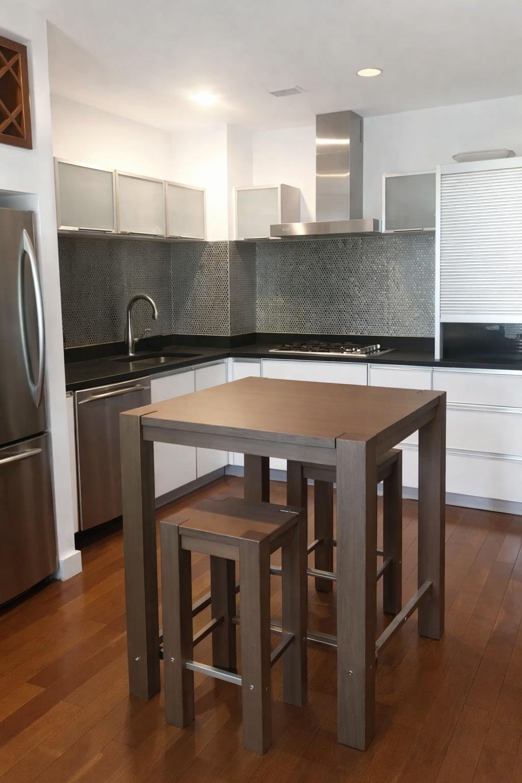 Modern kitchen with a dark mosaic backsplash and a wood table with stools.