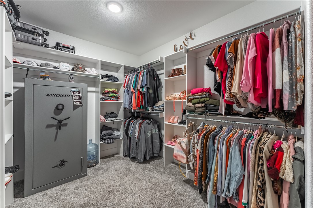 Walk-in closet with built-in clothing storage and a large Winchester safe.