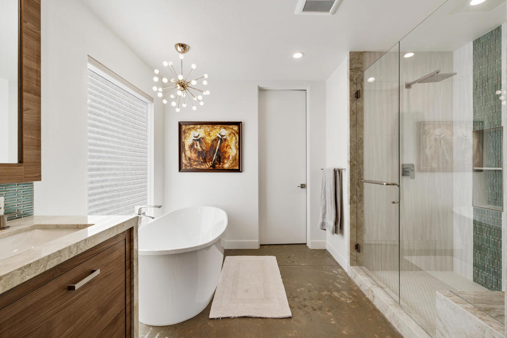 Modern bathroom with a freestanding tub, wood vanity, and glass walk-in shower.